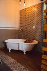 a bath tub in a bathroom with a wall at Clandestino Hotel Pila Seca in San Miguel de Allende