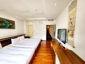 a room with two beds and a tv on a wall at 日月潭全家湖畔民宿-包棟烤肉釣魚九族纜車遊湖sup優惠票券 in Yuchi