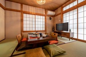 a living room with a table and a tv at Hatagaya House in Tokyo