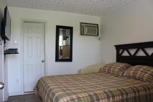 Le Marigot في فودرويدوريون: غرفة نوم مع سرير ومرآة على الحائط