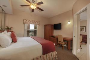 a bedroom with a bed and a desk and a ceiling fan at Kay's Sweet Suite Near Disney in Orlando