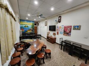 a room with a table and some stools and a tv at 日月潭全家湖畔民宿-包棟烤肉釣魚九族纜車遊湖sup優惠票券 in Yuchi