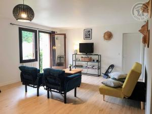 ein Wohnzimmer mit einem Sofa, einem Tisch und Stühlen in der Unterkunft Gîte Arronville, 2 pièces, 3 personnes - FR-1-649-15 