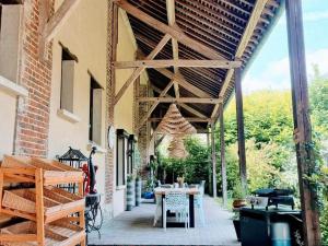 een patio met een houten pergola bij Gîte Arronville, 2 pièces, 3 personnes - FR-1-649-15 