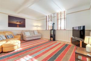 uma sala de estar com um sofá e uma televisão em Wallingbrook Lodge em Chulmleigh