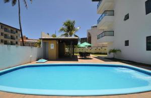 a large blue swimming pool next to a building at Porto de Galinhas - Apartamento Flat Sea Residence 304 in Porto De Galinhas