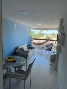 a living room with a couch and a table at Porto de Galinhas - Apartamento Flat Sea Residence 304 in Porto De Galinhas