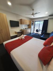 a bedroom with a large white bed with a red blanket at Abode37 Motel Emerald in Emerald