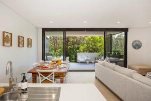 Una cocina y una sala de estar con un sofá y una mesa. en Obsidian Blue Huskisson, en Huskisson 23 fotos más