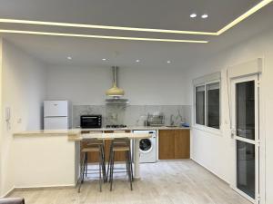 a kitchen with a counter and stools in it at Appartement de standing in Martil