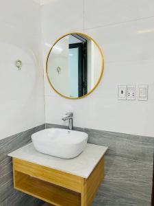 a bathroom with a white sink and a mirror at Tùng Dương Homestay in Cao Bằng
