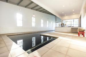 una piscina en una habitación grande con una mesa y una silla en Springbank House en Jindy Andy