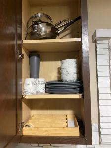 a cupboard with plates and dishes in a kitchen at Adaora's Oasis private room in Millersville