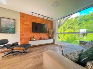 a living room with a couch and a tv at Pousada Altas Natureza in Florianópolis