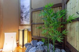 roślina w rogu pokoju z kamieniami w obiekcie Second kuwamura building w Tokio
