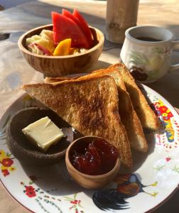 - une assiette de pain grillé, un bol de fruits et une tasse de café dans l'établissement SAJA Cottage, Gili Meno, à Gili Meno