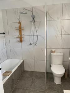 a bathroom with a shower and a toilet and a tub at Rosslyn Bay Resort Yeppoon in Yeppoon