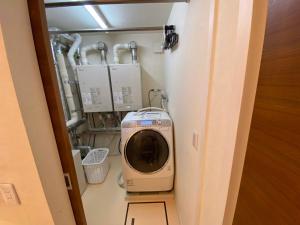a room with a washing machine in a room at Aster in Kutchan