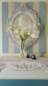 a vase of flowers on a table with a mirror at Elia in Skala Fourkas