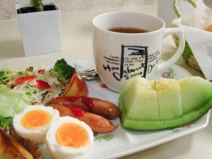 a plate of food with eggs and a cup of tea at Hotel Cotton 100% in Nara