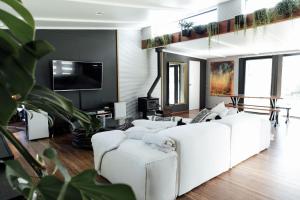 ein Wohnzimmer mit weißen Sofas und einem Flachbild-TV in der Unterkunft The Artemis Cottage in Fitzroy