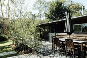 einen Tisch und Stühle mit einem Sonnenschirm auf einer Terrasse in der Unterkunft The Artemis Cottage in Fitzroy