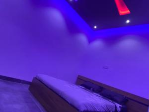a bed in a room with purple lights at RÉSIDENCE LA CENTENAIRE in Dakar