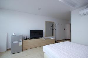 um quarto com uma cama e uma televisão de ecrã plano em VIEW Hotel Geoje em Geoje