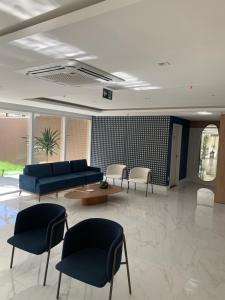 Una sala de estar con un sofá azul y sillas. en Aquarius Fortalezamar, en Fortaleza 42 fotos más