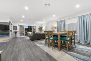 uma sala de jantar e sala de estar com mesa e cadeiras em OSPREY ISLAND RETREAT em Banksia Beach