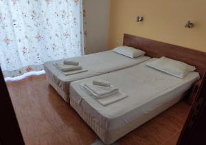 ein Schlafzimmer mit 2 Betten und weißen Handtüchern darauf in der Unterkunft Billy's two- bed apart for Rent at Sunny Beach in Sonnenstrand
