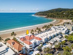 an aerial view of a resort and the beach at Beachfront luxury, Hastings Street in Noosa Heads