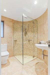 a bathroom with a shower and a toilet and a sink at Beachfront luxury, Hastings Street in Noosa Heads +9 photos