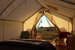 Waitsfield的住宿－Madbush Falls，田野上带床和椅子的帐篷