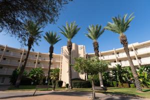 a group of palm trees in front of a building at lasuita- exclusive suites cesarea- sea view suite in Caesarea