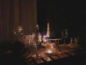 un tavolo con bicchieri da vino e una bottiglia sopra di Bendheka - Cliff Front Cottages Coorg a Gonikoppal