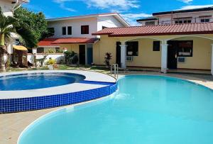 una gran piscina azul frente a una casa en RedDoorz at Carlton-Martin Hotel Masbate City, en Cangbaliguia