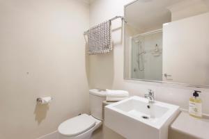 Baño blanco con aseo y lavamanos en Casa Toucan - 2 bedroom apartment close to the airport, en Perth