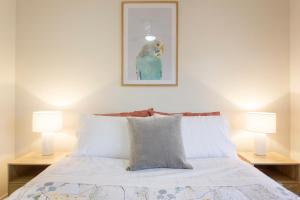 Casa Toucan - 2 bedroom apartment close to the airport في بيرث: غرفة نوم بسرير مع مصباحين