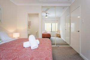 a bedroom with a bed and a mirror at Casa Toucan - 2 bedroom apartment close to the airport in Perth