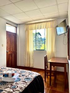 - une chambre avec un lit, un bureau et une fenêtre dans l'établissement Hospedaje Familiar Laos, à Oxapampa
