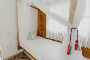 ein kleines Schlafzimmer mit einem Bett und einem Fenster in der Unterkunft UUTTAAKA Eco-Hotel in Palomino
