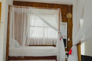a bedroom with a white bed with a window at UUTTAAKA Eco-Hotel in Palomino