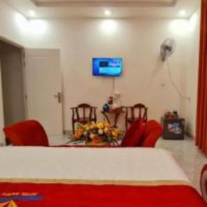 a room with red chairs and a table and a television at Happy 2 Hotel Bình Dương in Bến Cát