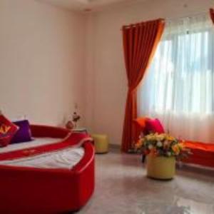 a living room with a red bed and a window at Happy 2 Hotel Bình Dương in Bến Cát