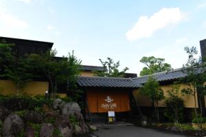 a building with a sign on the side of it at OMOLOSO Hostel　オモロソウ ホステル in Beppu