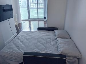 a large bed in a room with two chairs at ICE Condominiums in Toronto