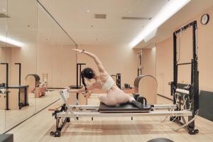 a woman on a pilates reformer in a gym at Hyatt Regency Shenzhen Yantian in Shenzhen
