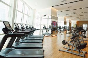 a gym with rows of treadmills and elliptical machines at Hyatt Regency Shenzhen Yantian in Shenzhen
