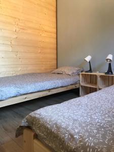 two beds in a room with wooden walls at Bieszczadzki Luz in Dwernik